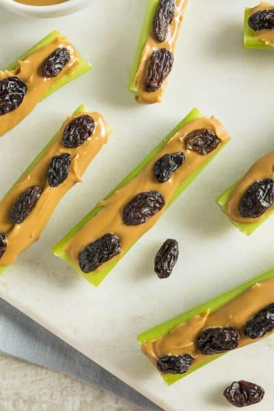 Photo of celery and peanut butter snacks with raisins on top.